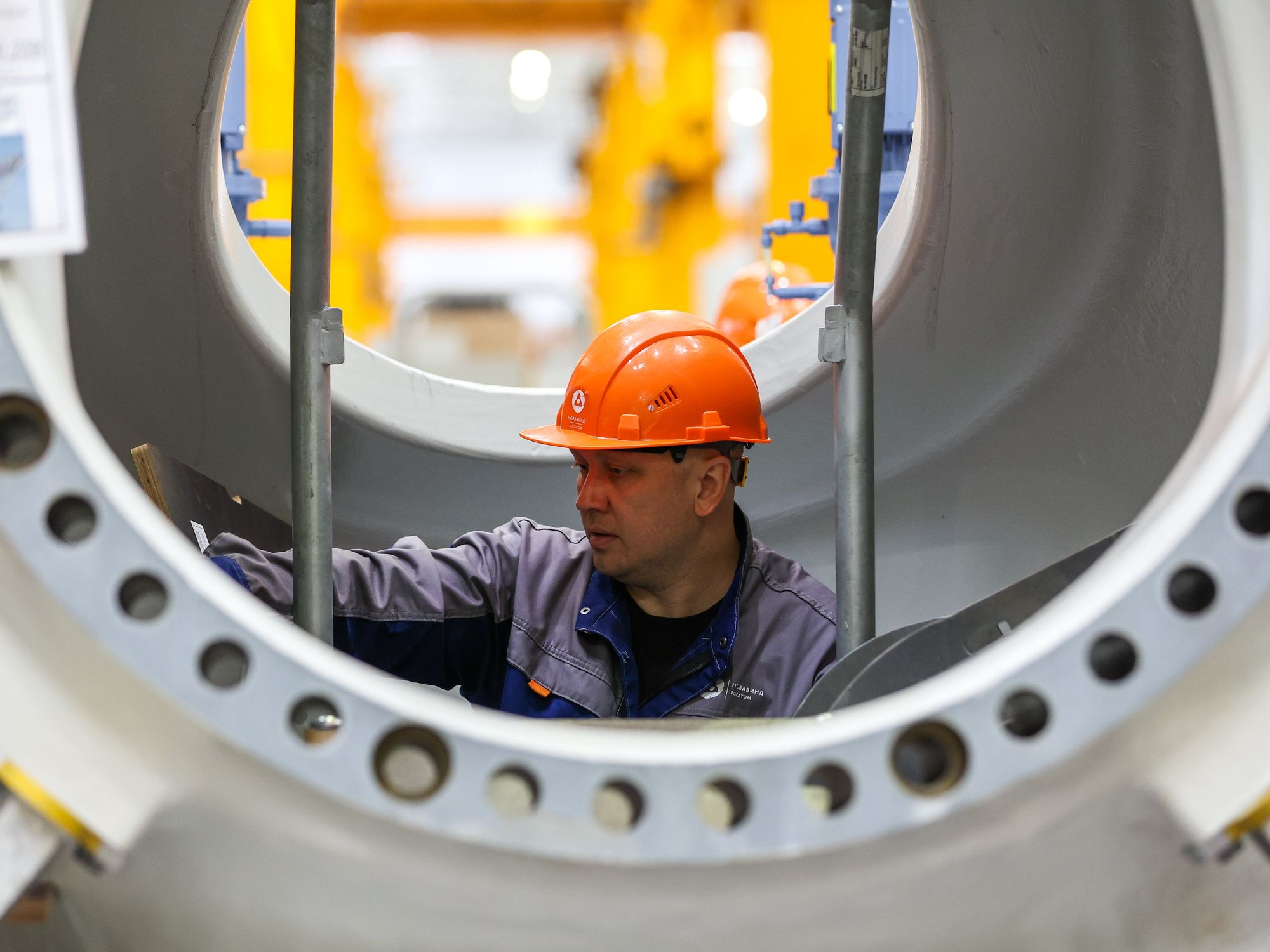 photo of a worker with an orange hard hat in a turbine factory