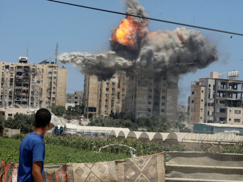 photo of a young man watching a building being blown up