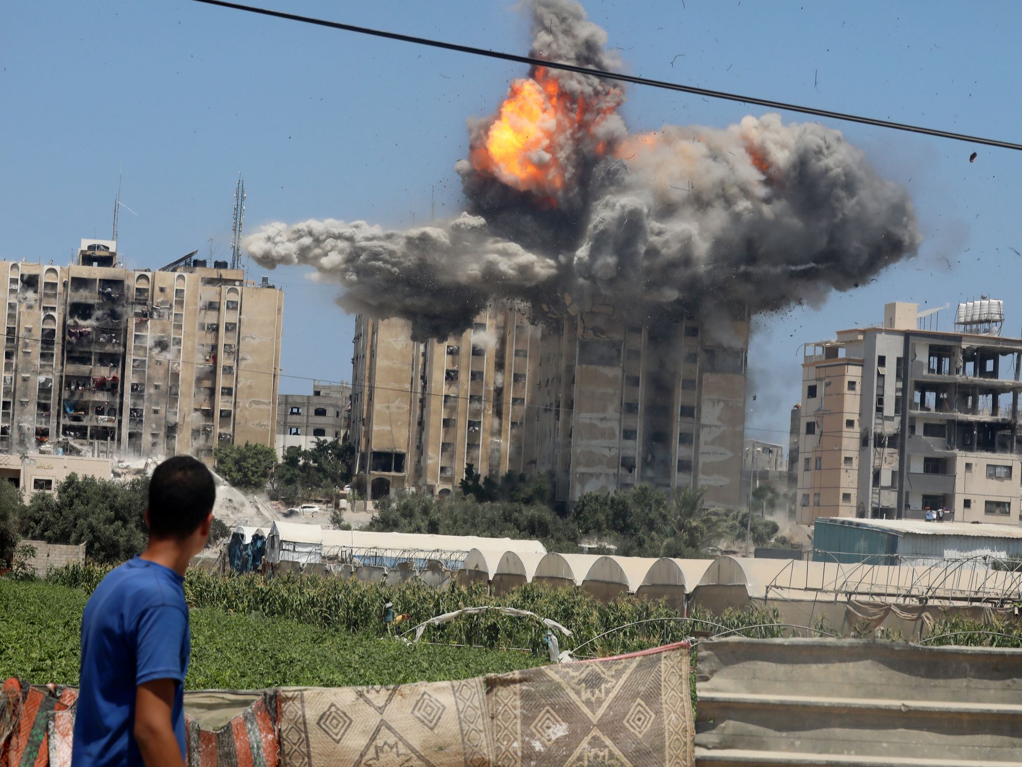 photo of a young man watching a building being blown up
