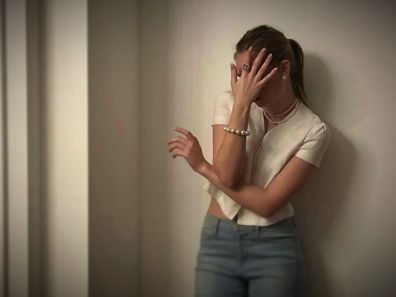 Photo of a young woman hiding her face