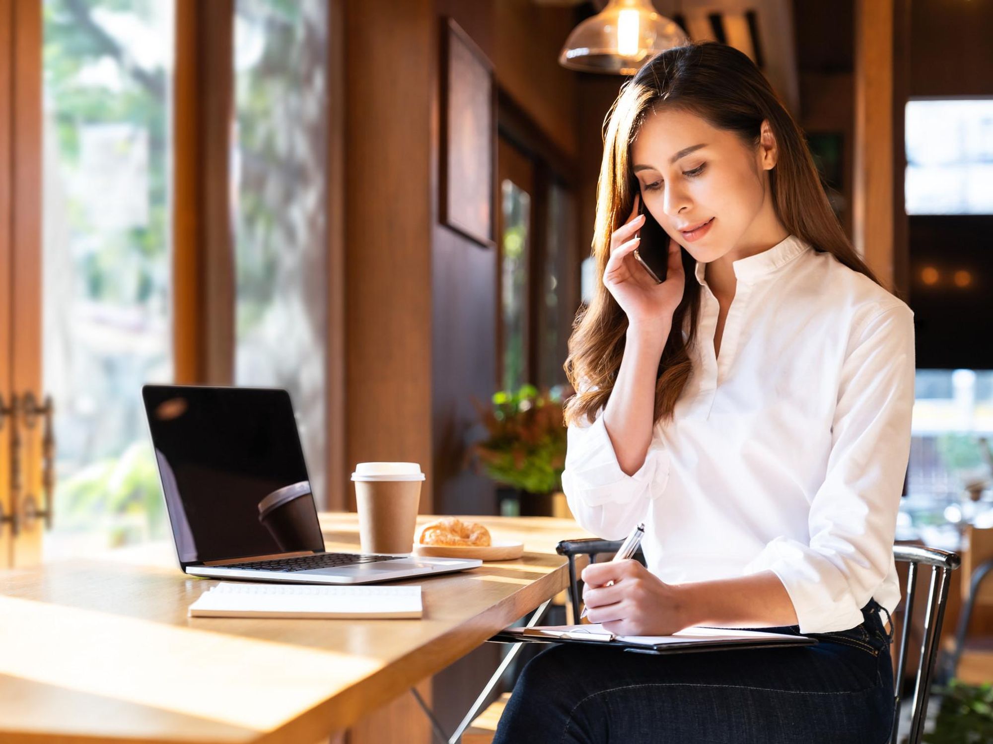 Photo of a young woman working in a café.