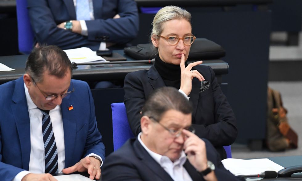 photo of Alice Weidel listening to debate next to a man who is reading his tablet