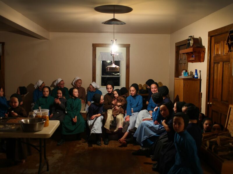 Photo of Amish girls gathering after a dinner to talk and play at the Mullet farmhouse