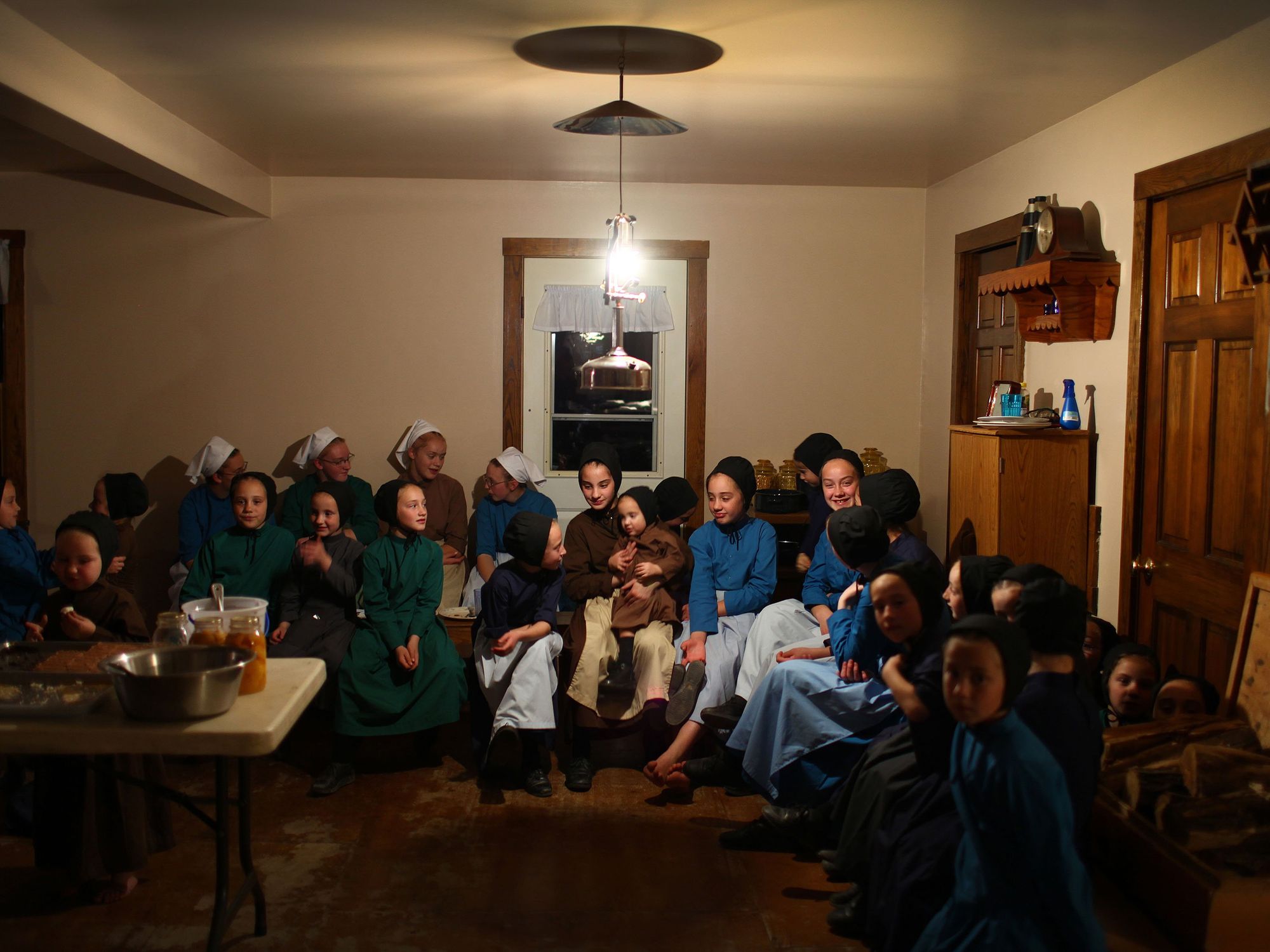 Photo of Amish girls gathering after a dinner to talk and play at the Mullet farmhouse