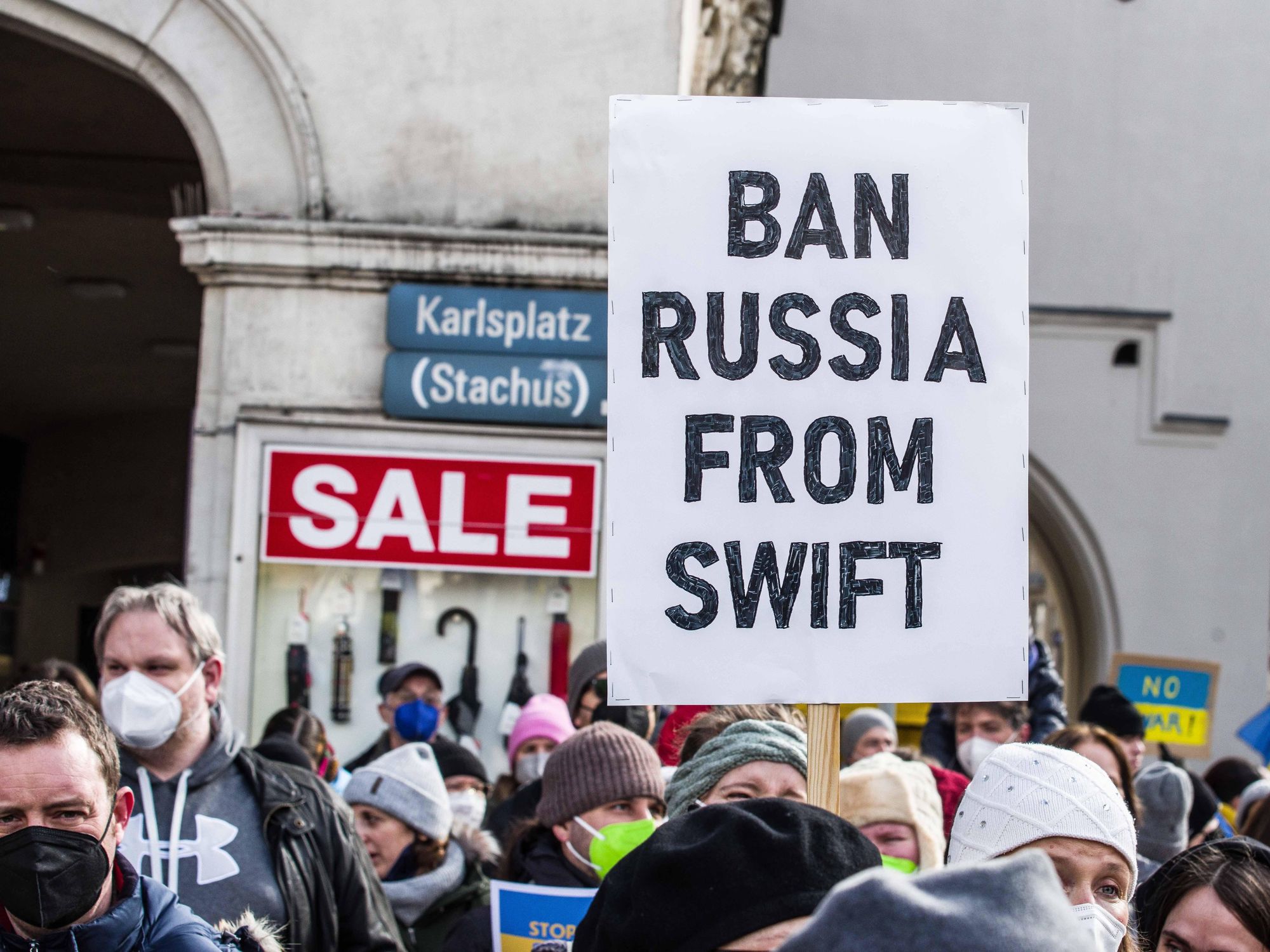 Photo of an anti-Ukraine war protest with a placard that reads "Ban Russia from Swift"