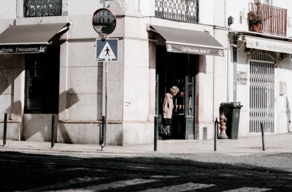 Photo of an elderly woman exiting a café in Lisbon, Portugal
