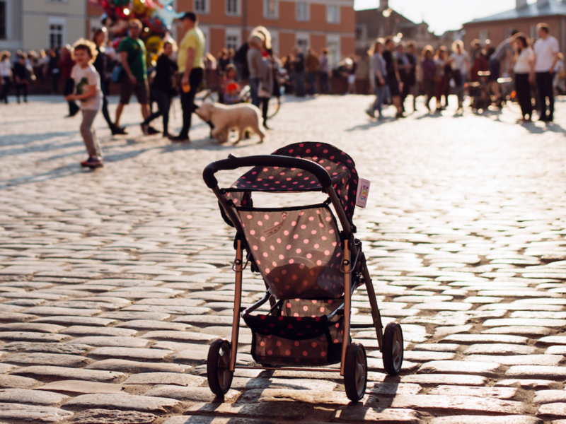 Photo of an empty stroller in the middle of a crowded square in Warsaw, Poland