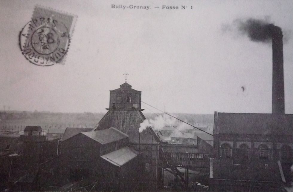 photo of an old coal mine with smoke