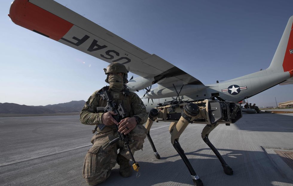 Photo of an U.S. Air Force soldier kneeling next to a "robotic dog" during an exercise near Las Vegas