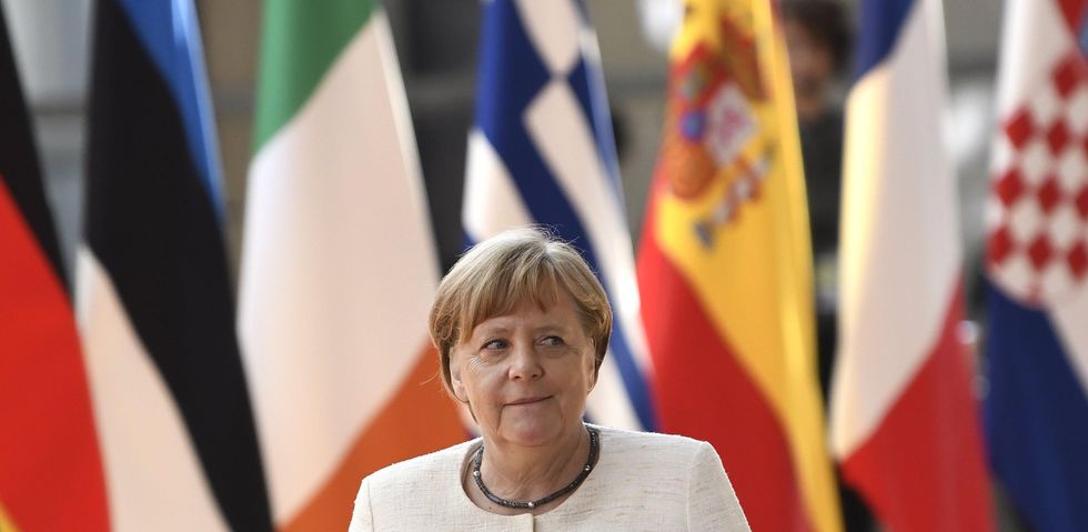 Photo of Angela Merkel with flags behind her