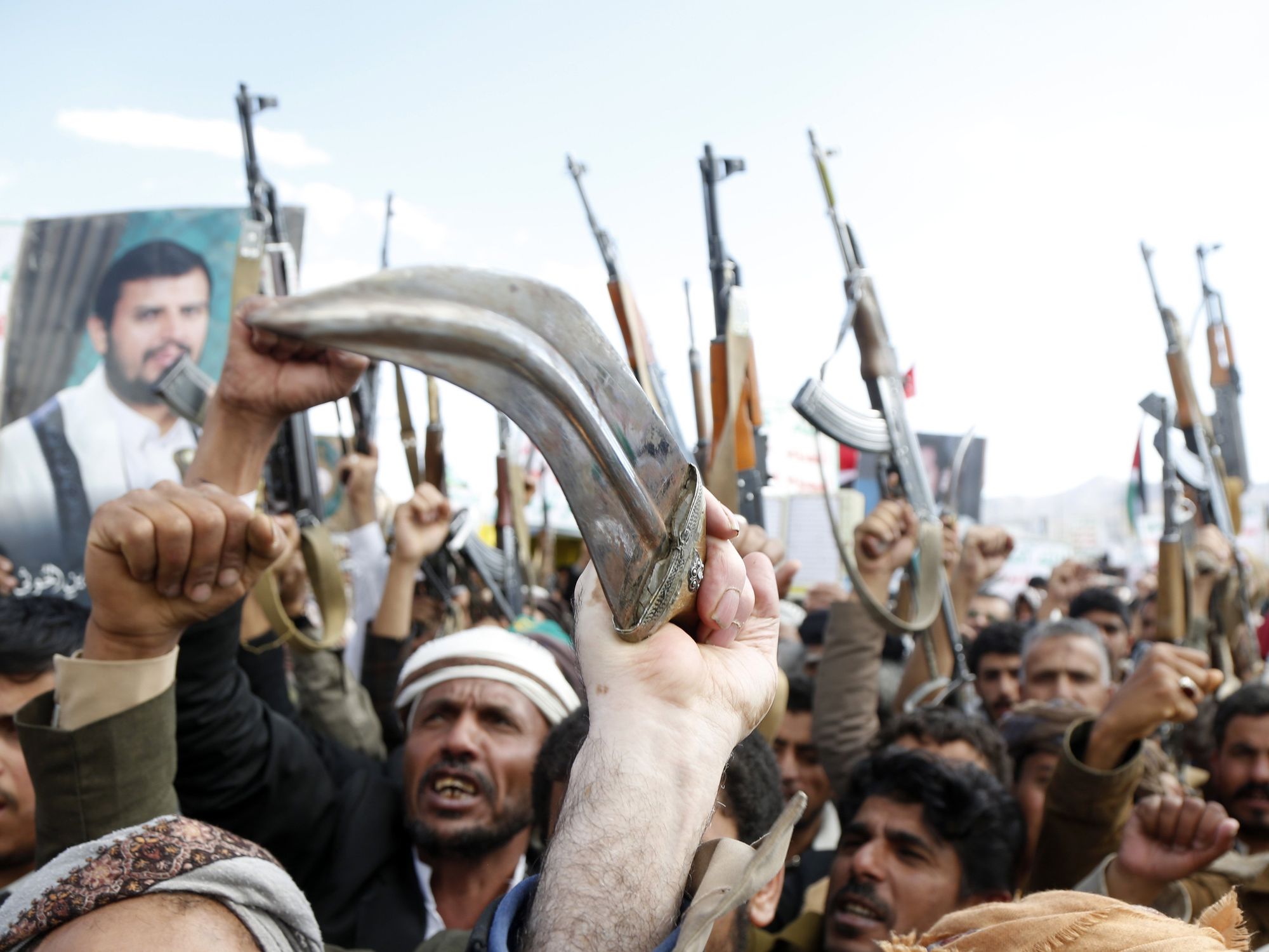 Photo of angry protestors holding rifles and knives up as part of anti-U.S. demonstrations in Sanaa, Yemen, on March 17