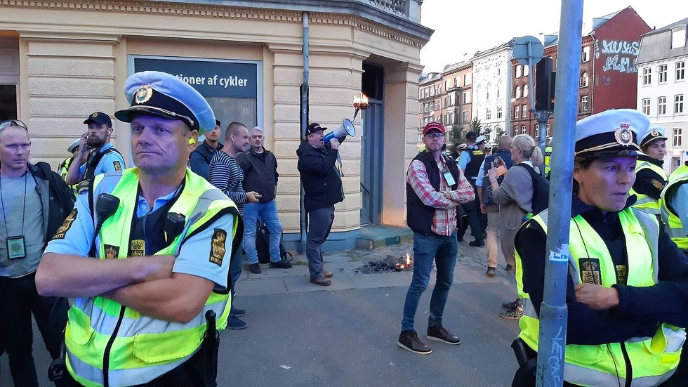 Photo of anti-Islam politician Rasmus Paludan burning a quran during a rally