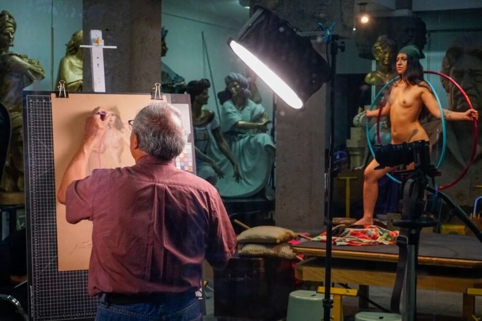 Photo of artist Víctor Gutiérrez drawing Viridiana López, an art model