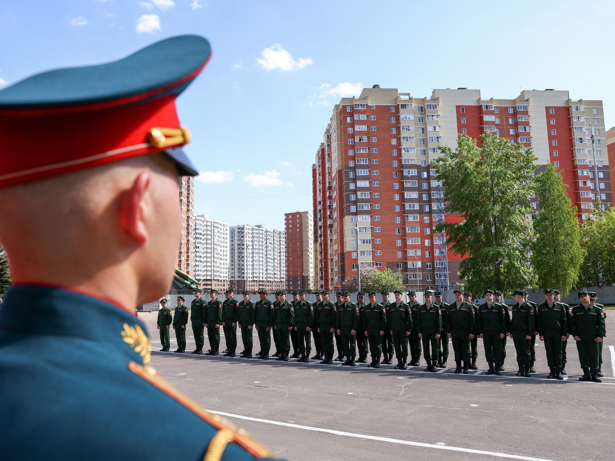photo of back of officer head as he observes lineup of recruits