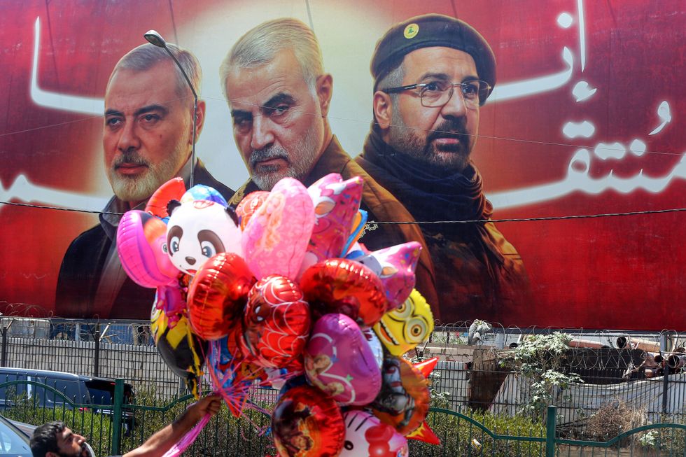 Photo of balloons floating in front of a poster shows former Hamas leader Ismail Haniyeh, Qasem Soleimani, head of Iranian Islamic Revolutionary Guard Brigade and top pro-Iranian Hezbollah commander Fouad Shukur. All three were assassinated in recent years.