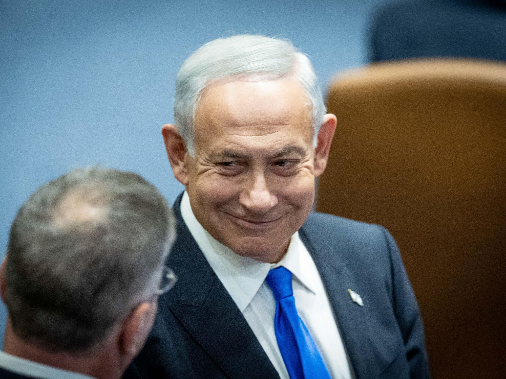 Photo of Benjamin Netanyahu listening to someone speak