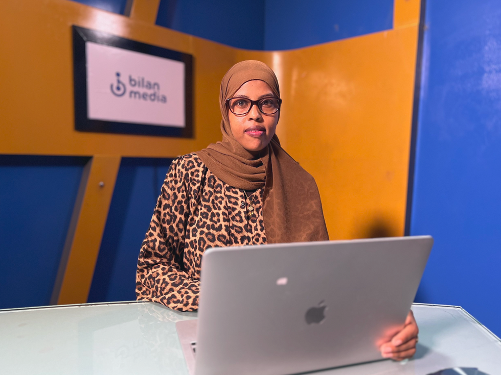 Photo of Bilan's ​editor-in-chief Hinda Abdi Mohamoud sitting at a computer