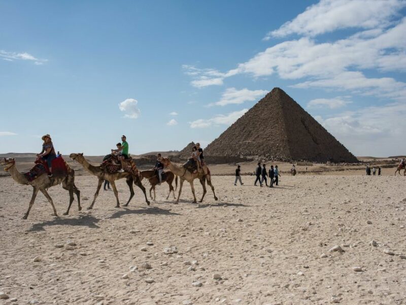 Photo of camels and tourists in front of the Menkaure Pyramid in Giza, Egypt
