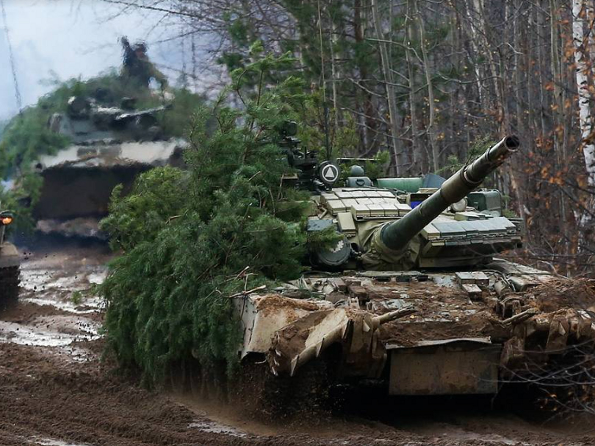 Photo of camouflaged Russian tanks driving through a forest