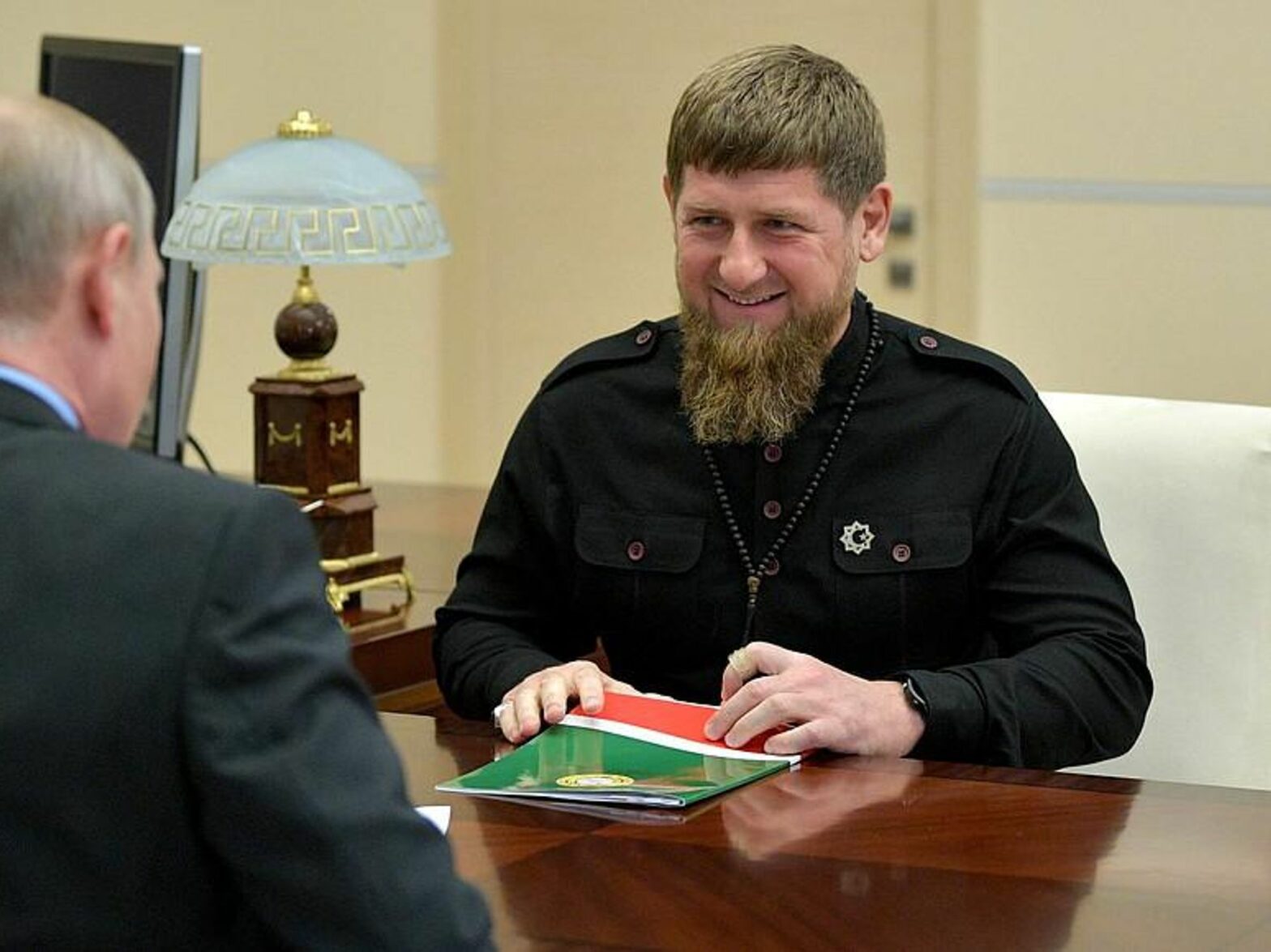 Photo of Chechen strongman Ramzan Kadyrov sitting at a desk with Russian President Vladimir Putin during a meeting in in Moscow