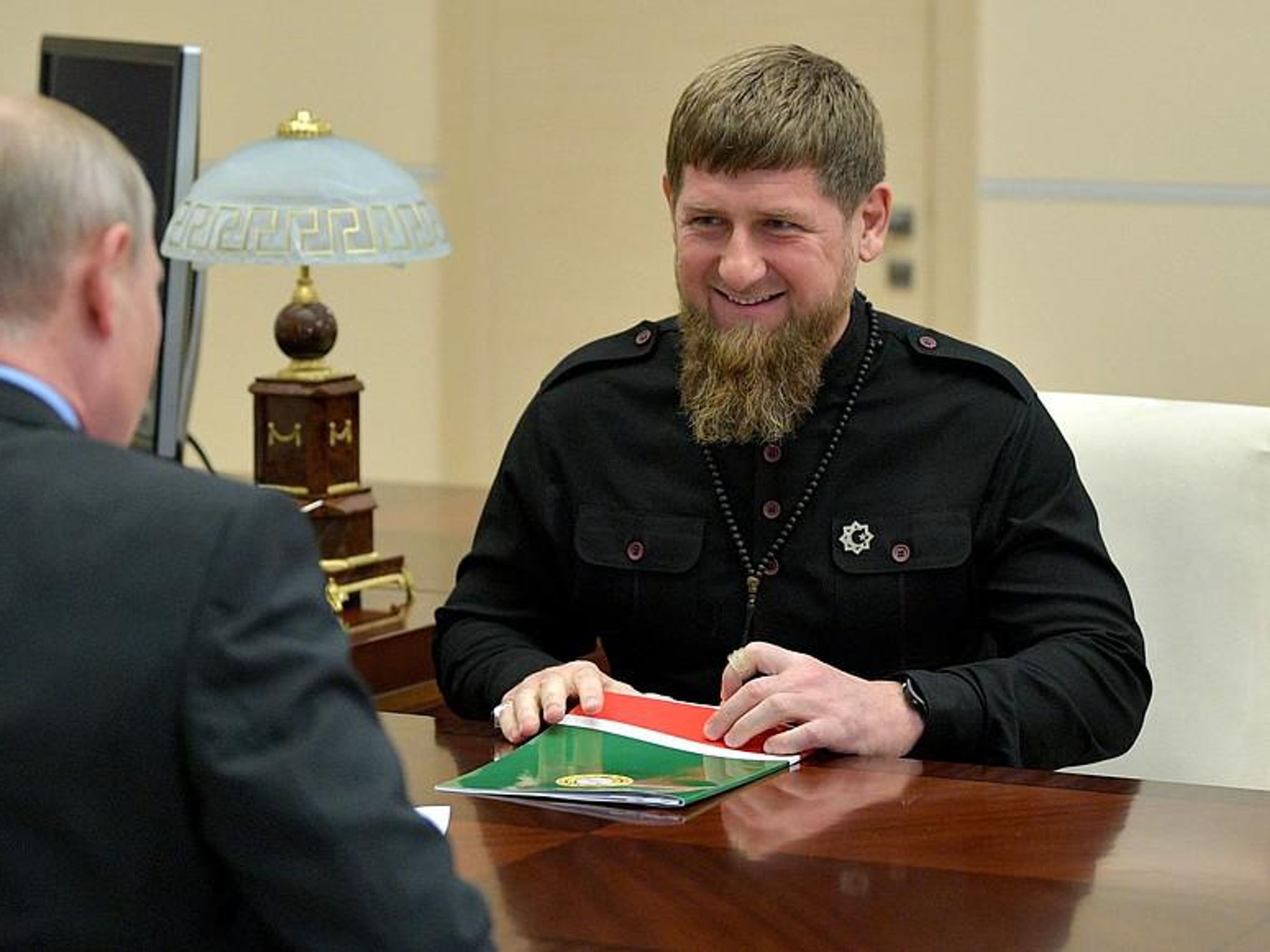 Photo of Chechen strongman Ramzan Kadyrov sitting at a desk with Russian President Vladimir Putin during a meeting in in Moscow