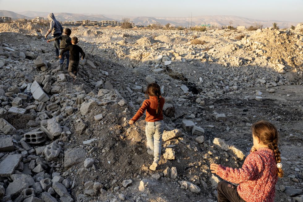 Photo of Children walking among the rubble in Damascus, Syria