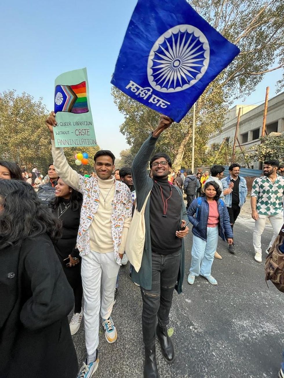 Photo of Dalit queer activist ​Jatin Pawar holding a sign that reads "no queer liberation without caste annihilation" at the 2023 Delhi Pride Parade