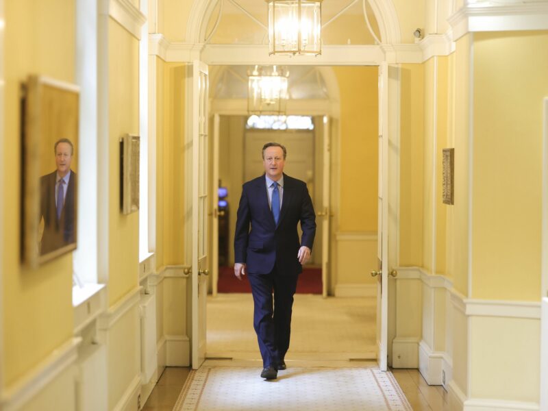 Photo of David Cameron walking down a hallway in Downing Street