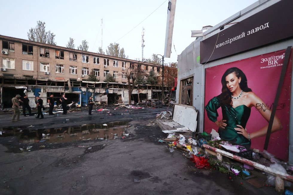 photo of debris after a missile attack including a billboard with an advertisement of a woman in a green dress