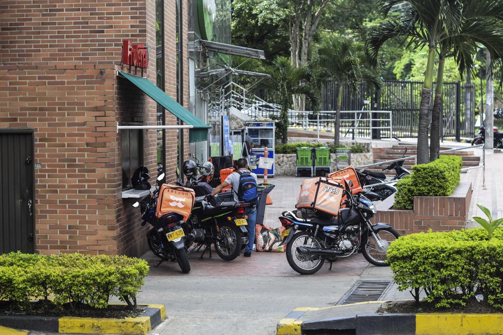 Photo of delivery workers waiting for orders outside supermarket i