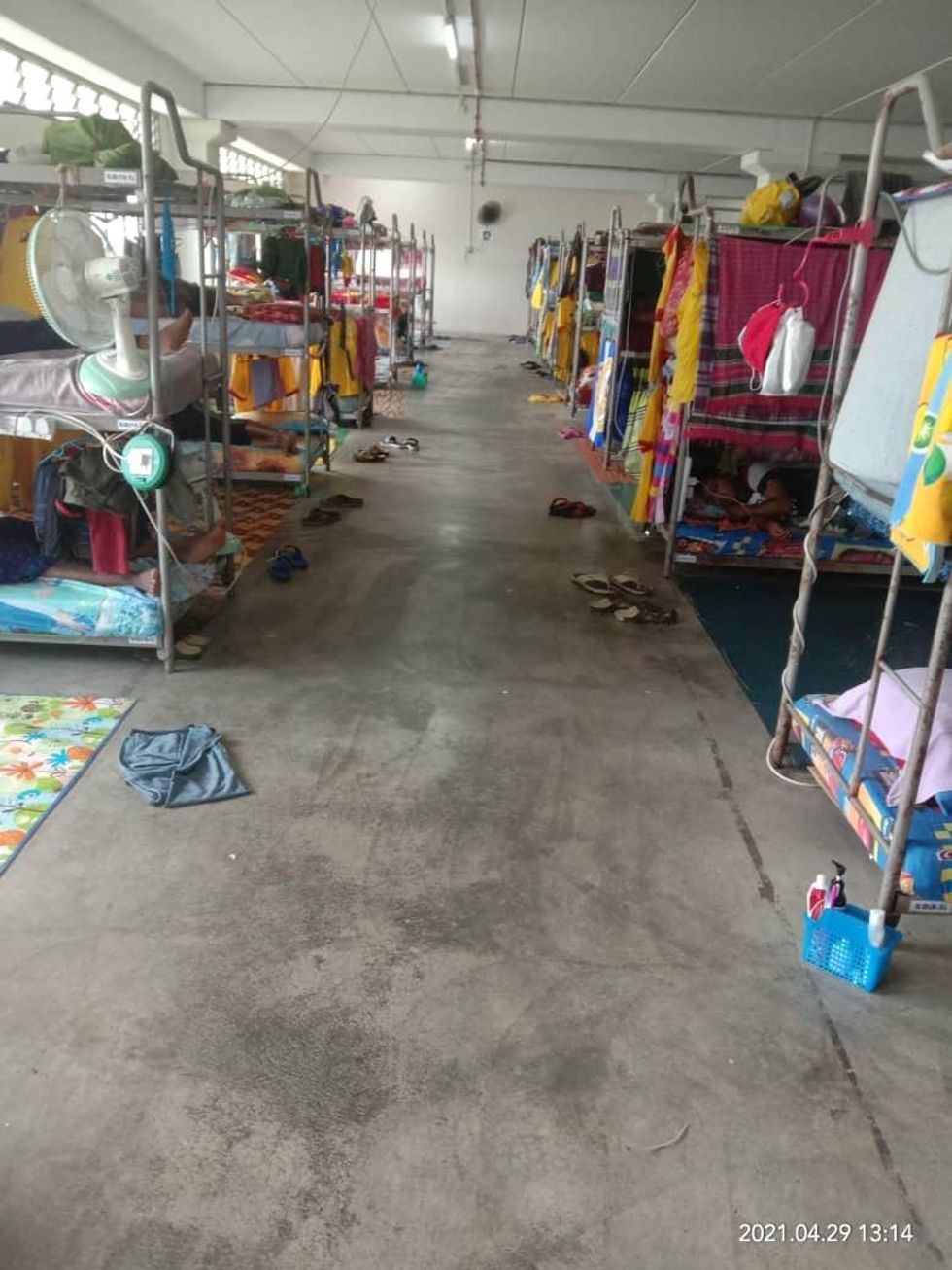 Photo of dirty dormitories taken by British labor rights activist Andy Hall showing bunk beds in a hangar-type room