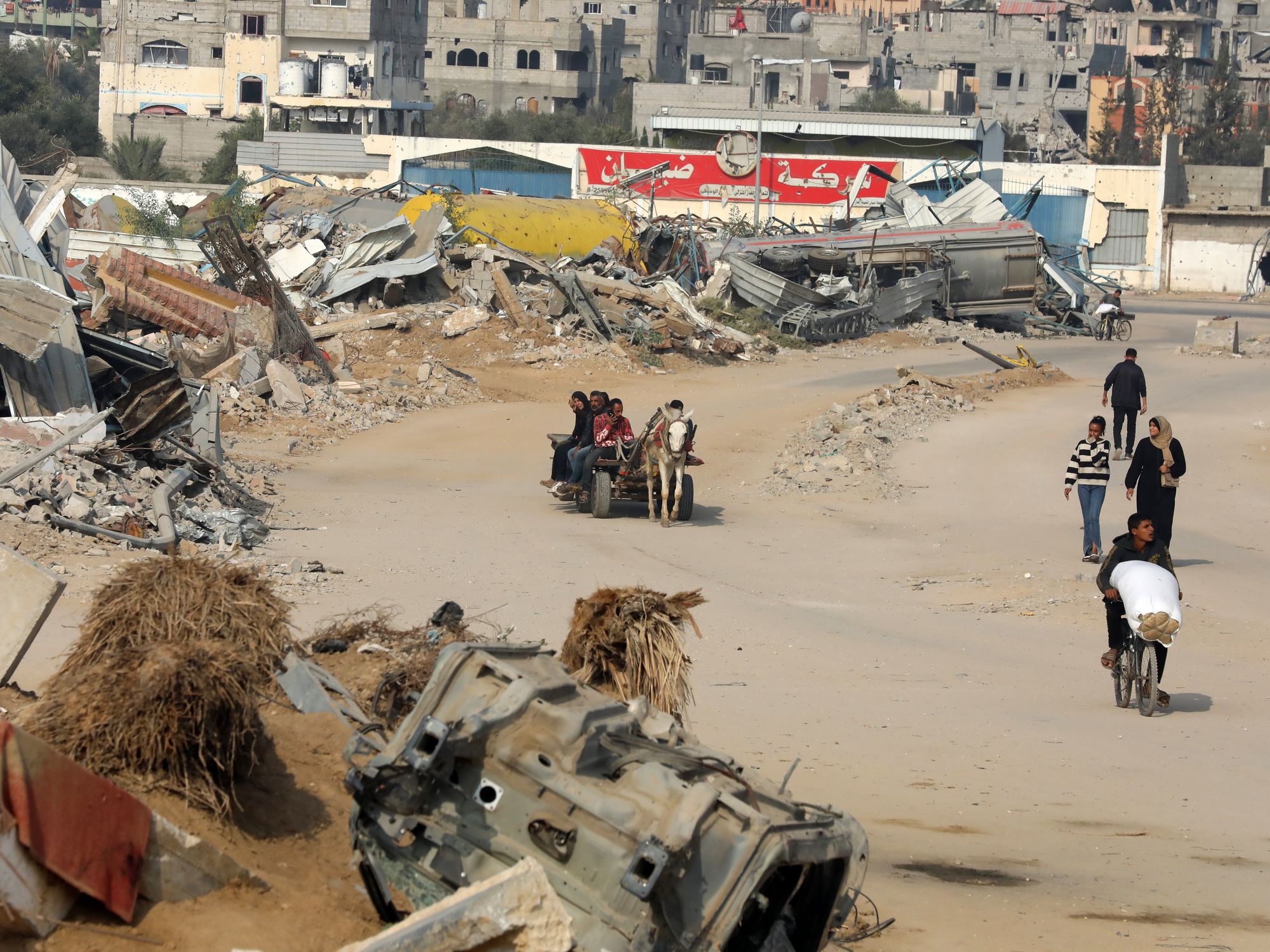 photo of displaced people walking and riding carts in refugee camp in Gaza