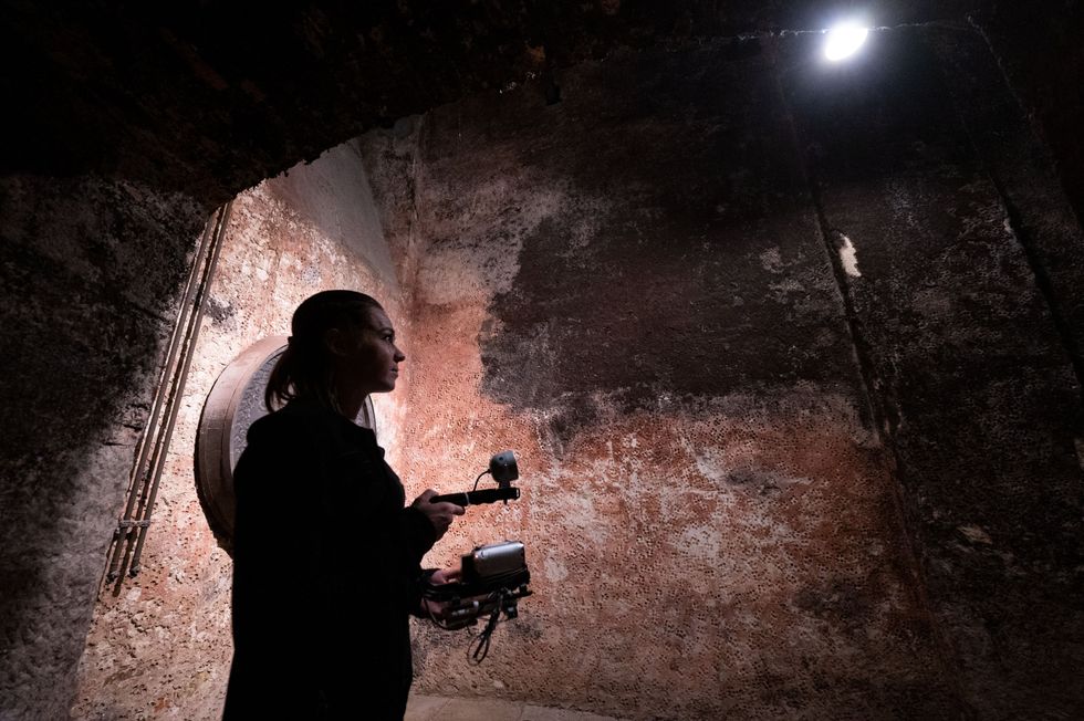 Photo of ​A member of a hobby ghost hunter team demonstrates the use of a camera with infrared light during a press event in the barrel cellar of the Ludwigsburg Residence Palace.
