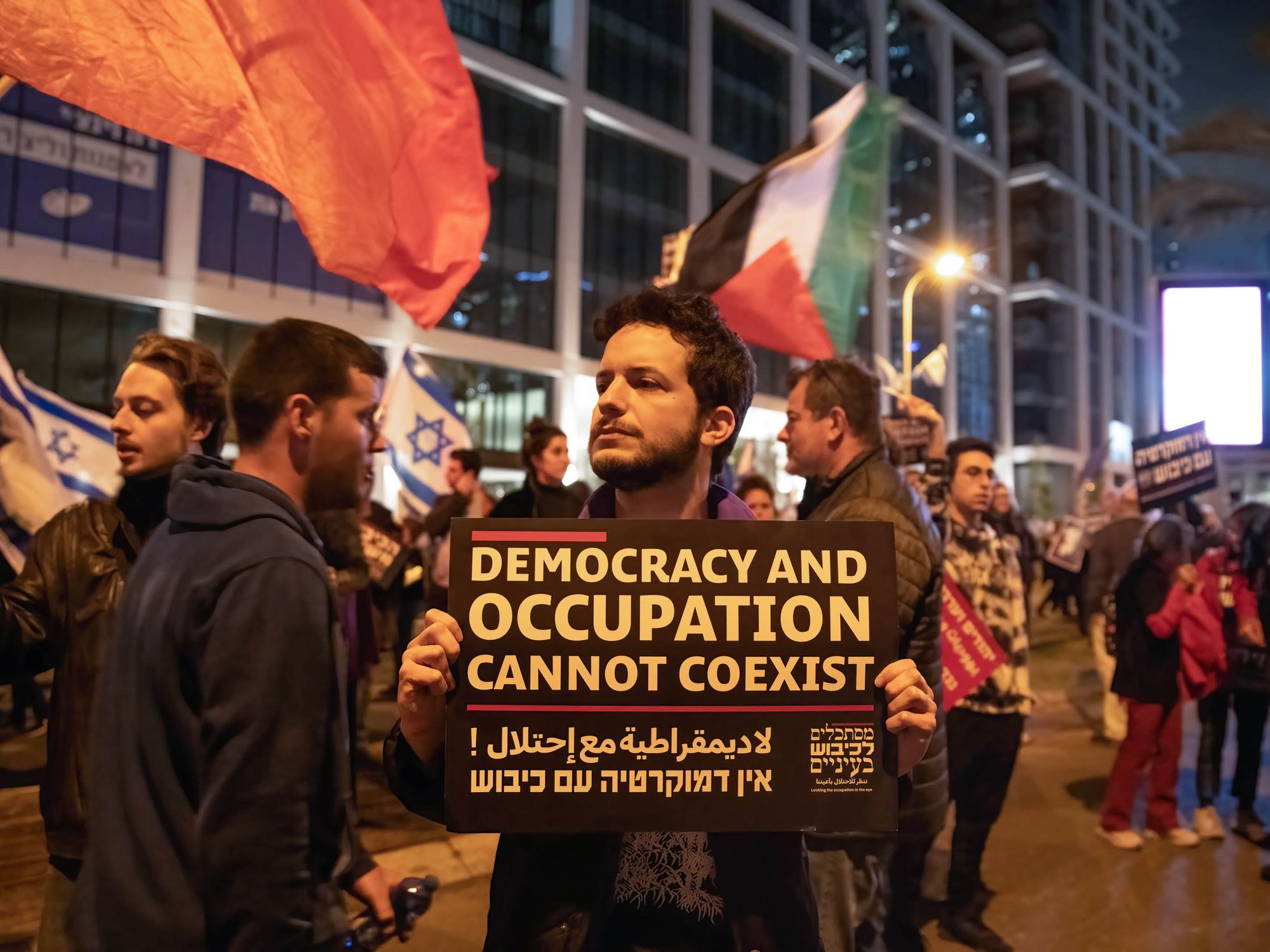 Photo of ​A protestor holding a sign against the Israeli occupation in the West Bank during a demonstration against the judicial reform in Tel Aviv, Israel, in March 2023.