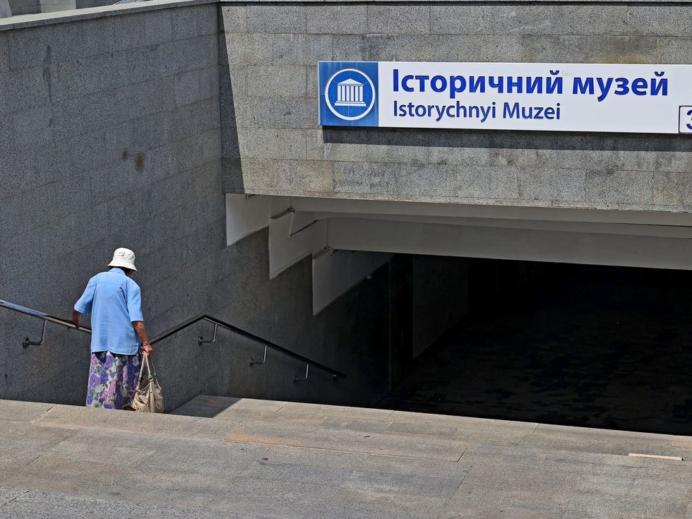 Photo of ​an elderly woman going down the steps of an underground passage at the Istorychnyi Myzei (Historical Museum) metro station, Kharkiv