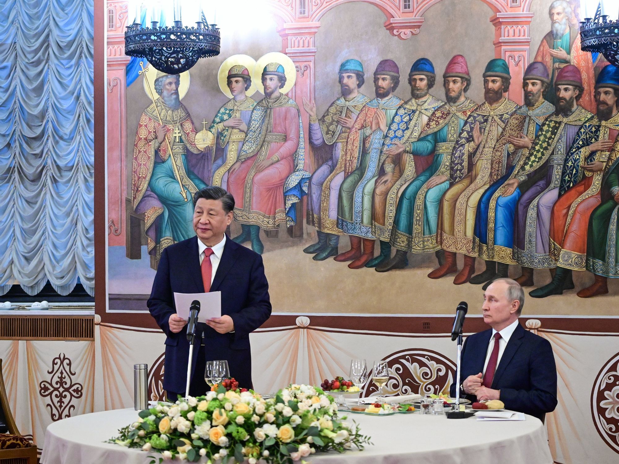 Photo of ​China's Xi Jinping giving a speech while Russia's Vladimir Putin is sitting down, as they meet in Moscow on March 21