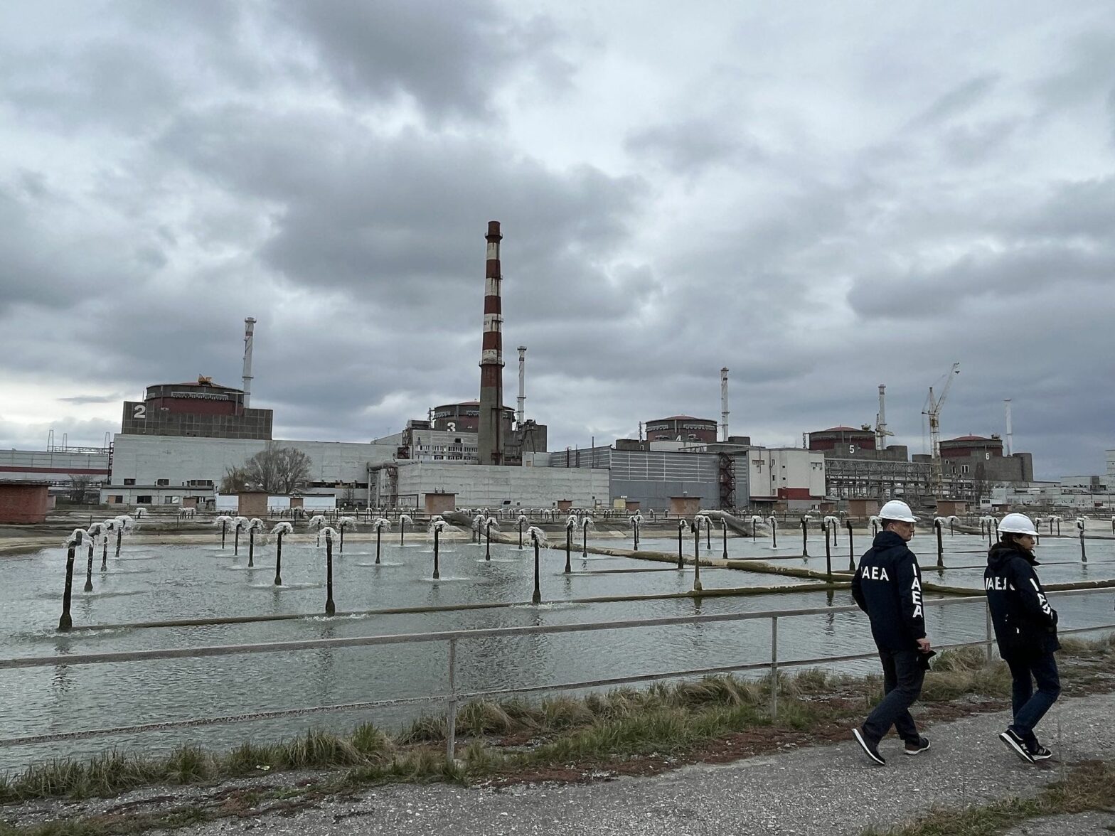 Photo of ​IAEA inspectors walking near the Zaporizhzhia power plant in March 2023