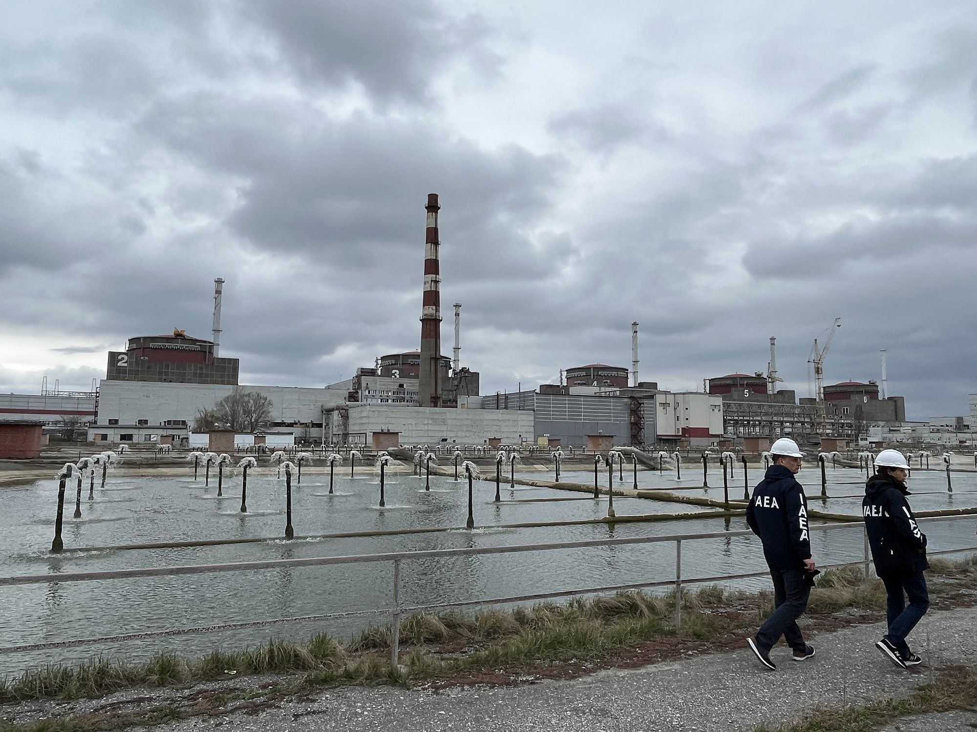 Photo of ​IAEA inspectors walking near the Zaporizhzhia power plant in March 2023