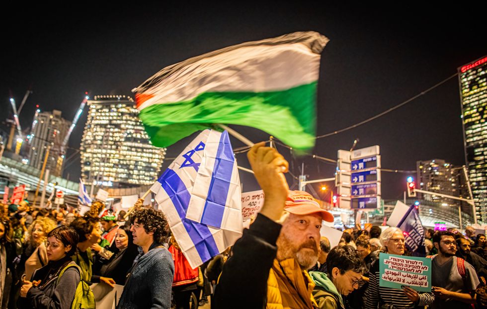 Photo of ​Protestors waving an Israeli and Palestinian flag during the demonstration in Tel Aviv against the violence committed by settlers in the West Bank town of Huwara.