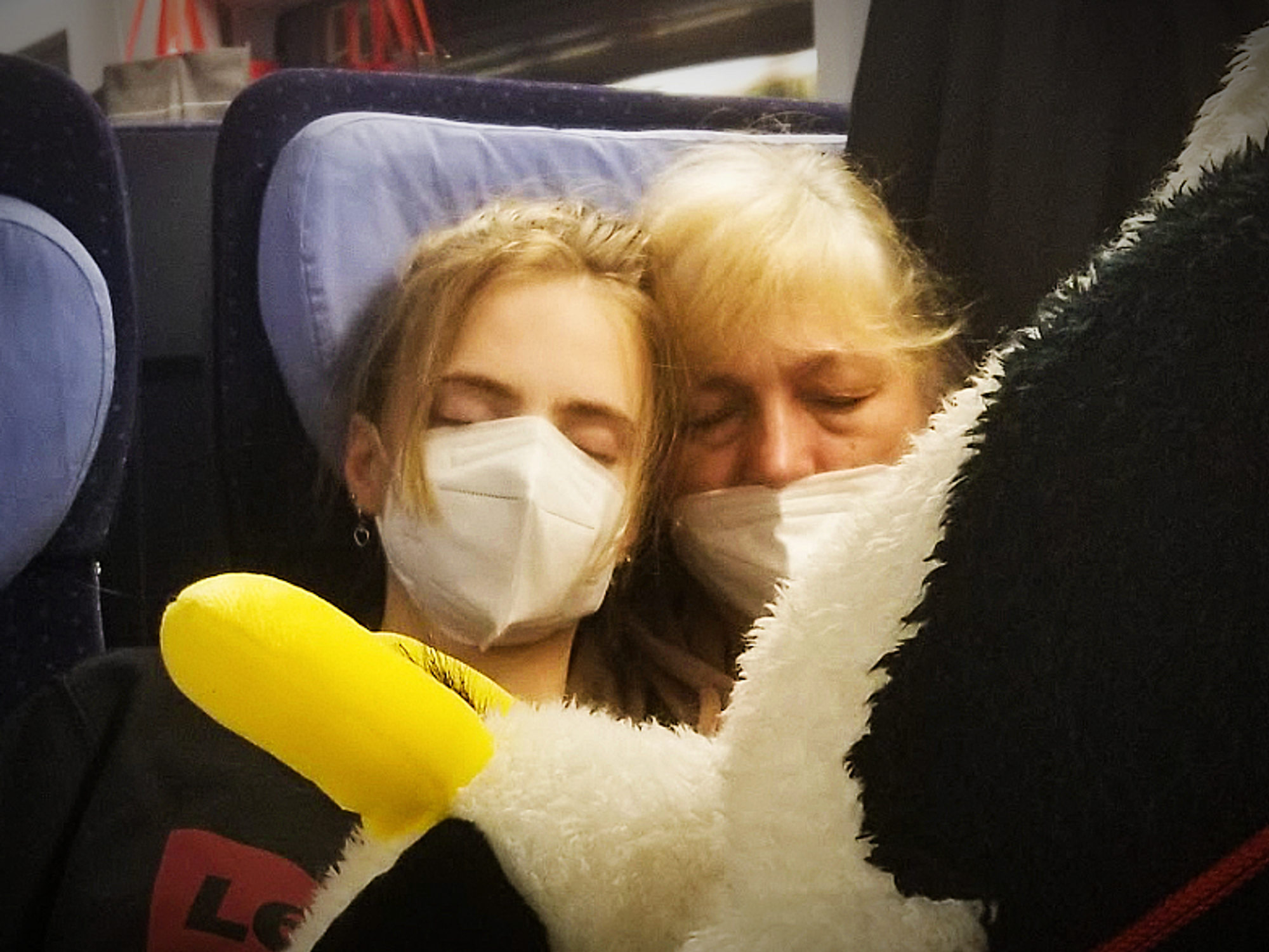 Photo of ​Sofiia and her grandmother sleeping on a train on their journey out of Ukraine