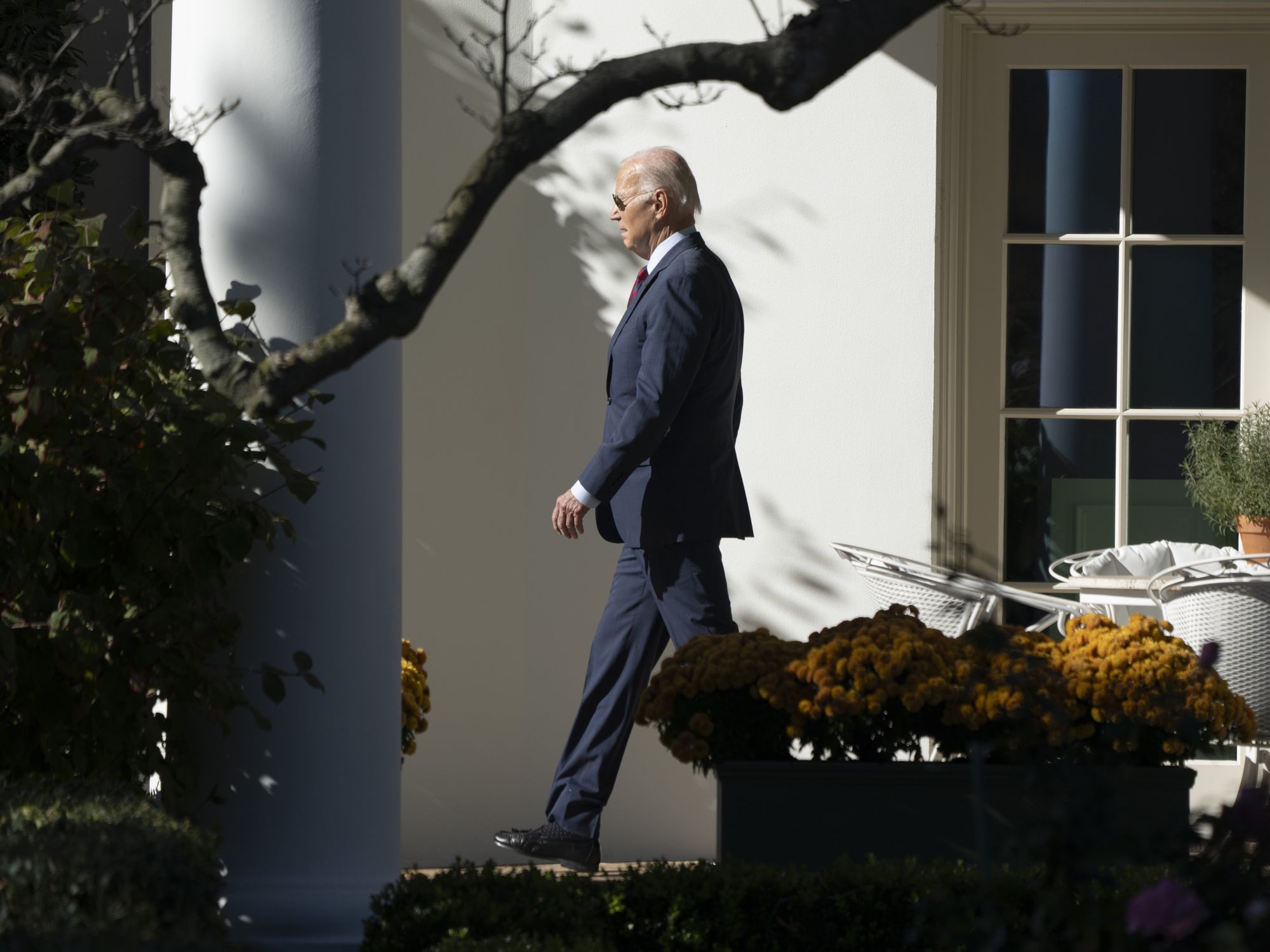 Photo of ​U.S. President Joe Biden walking toward the left of the image as he leaves the White House on Nov. 14