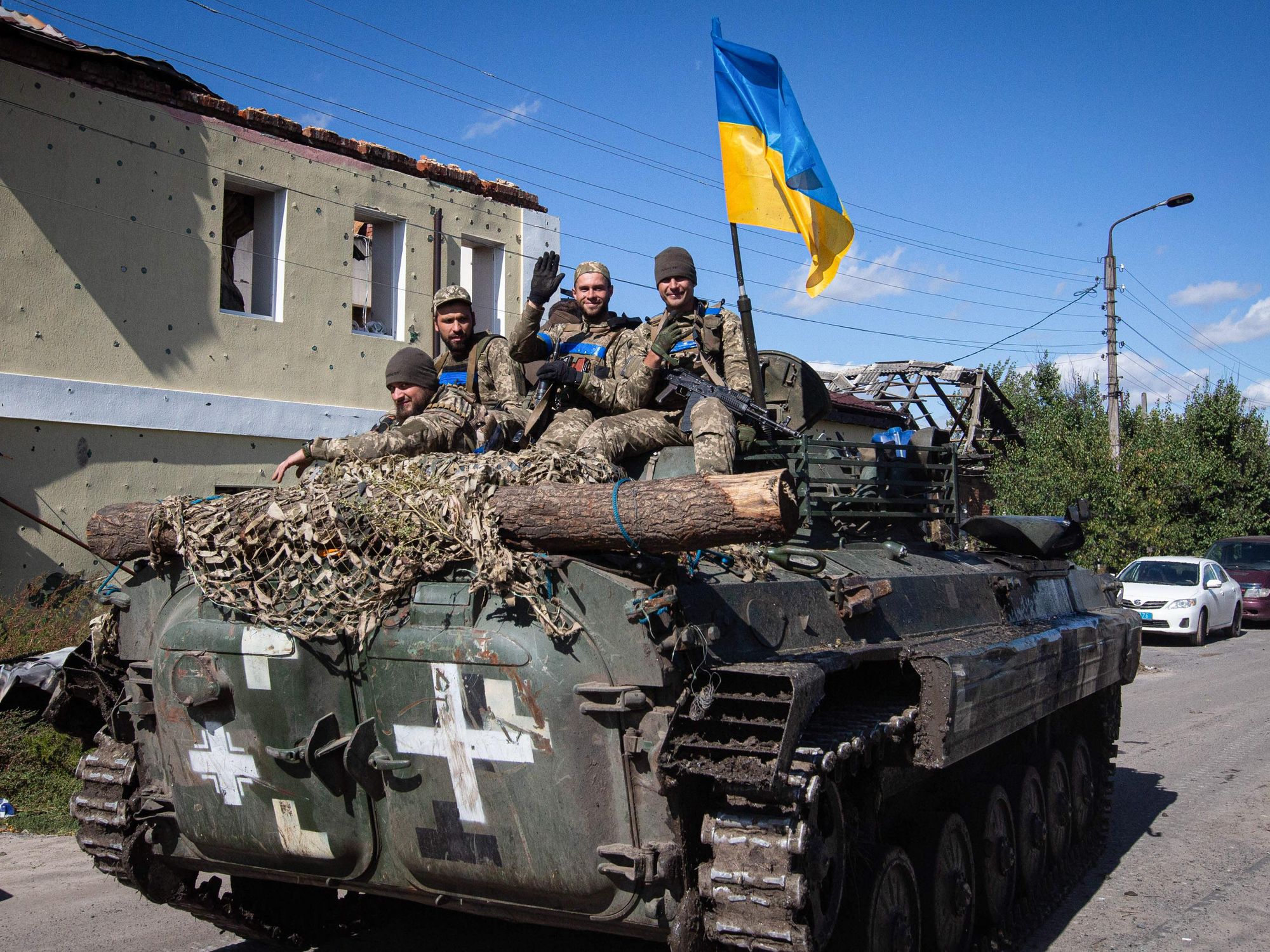 Photo of ​Ukrainian soldiers flying a Ukrainian flag while riding a tank through in Izium, near Kharkiv