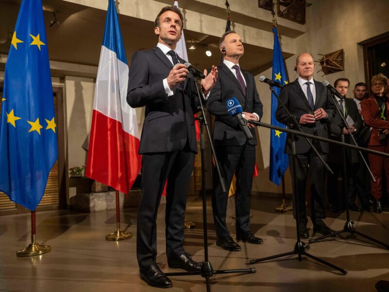 Photo of Emmanuel Macron speaking alongside Polish President Andrzej Duda and German Chancellor Olaf Scholz at the Munich Security Conference.