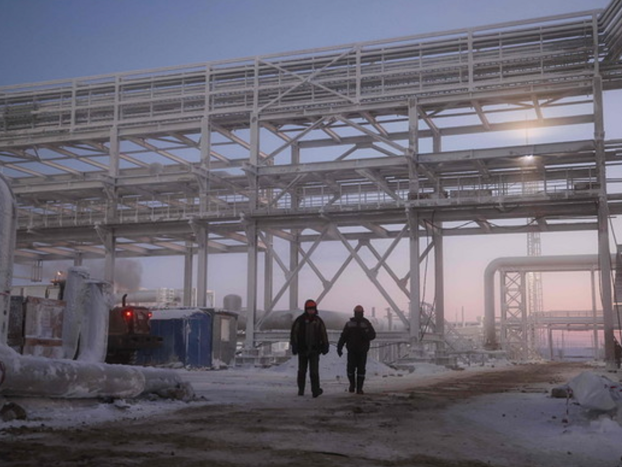 Photo of employees walking through frozen installations at the Utrenneye field in Murmansk Region, Russia.