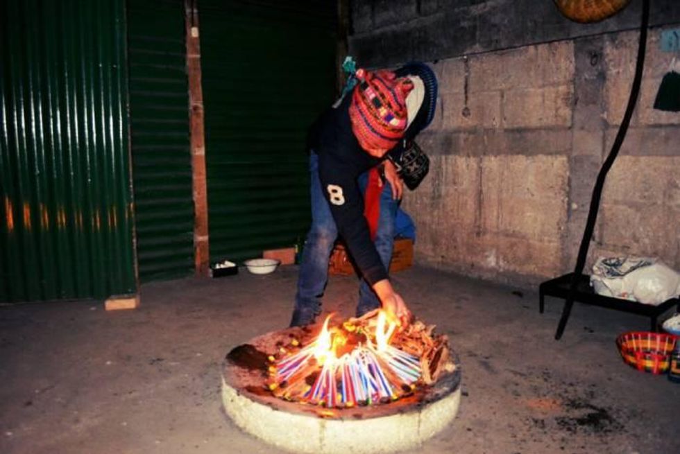 Photo of Enrique Salanic preparing the altar for a Mayan ceremony