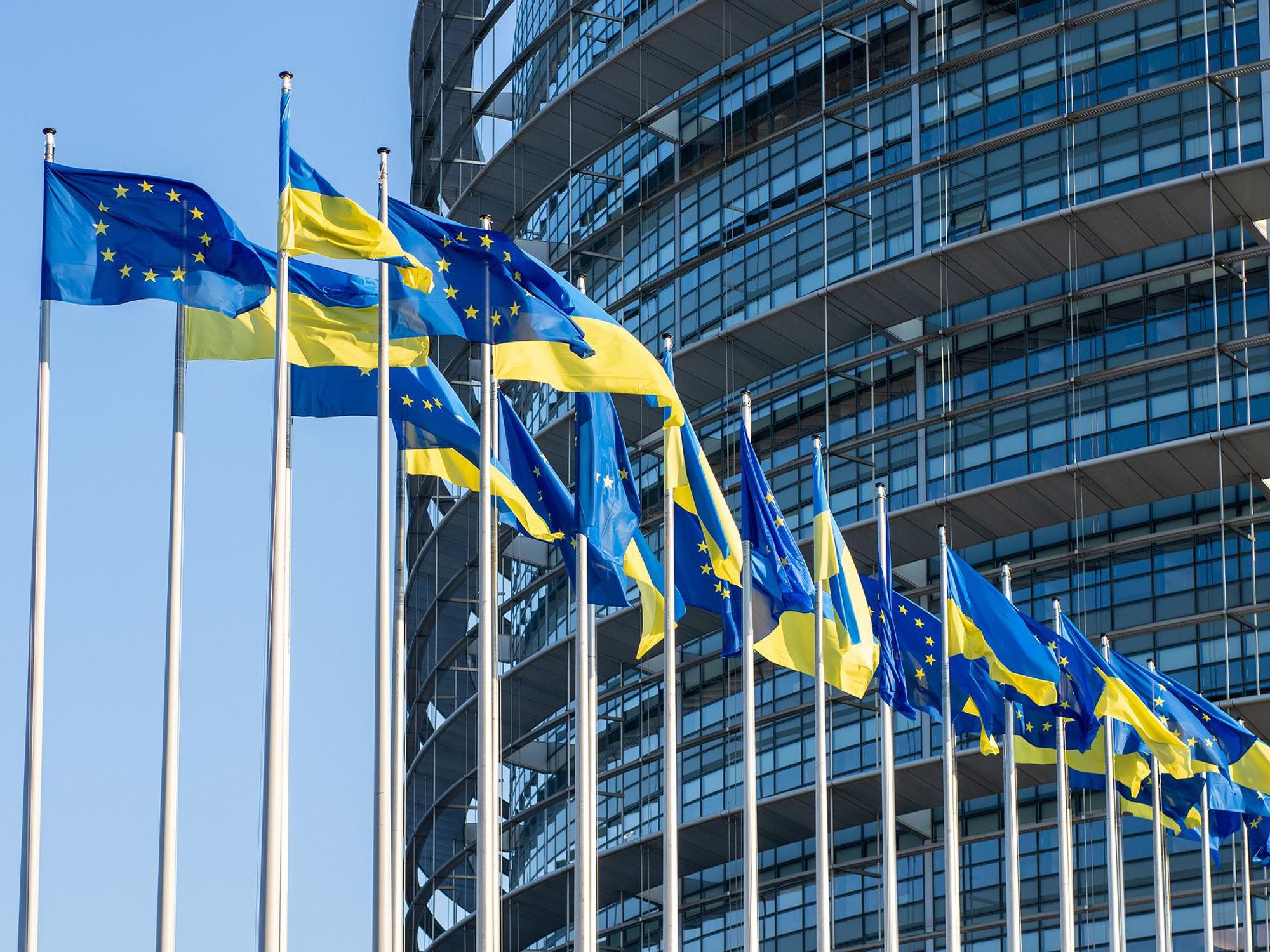 Photo of European and Ukrainian flags flying in front of the EU Parliament in Brussels