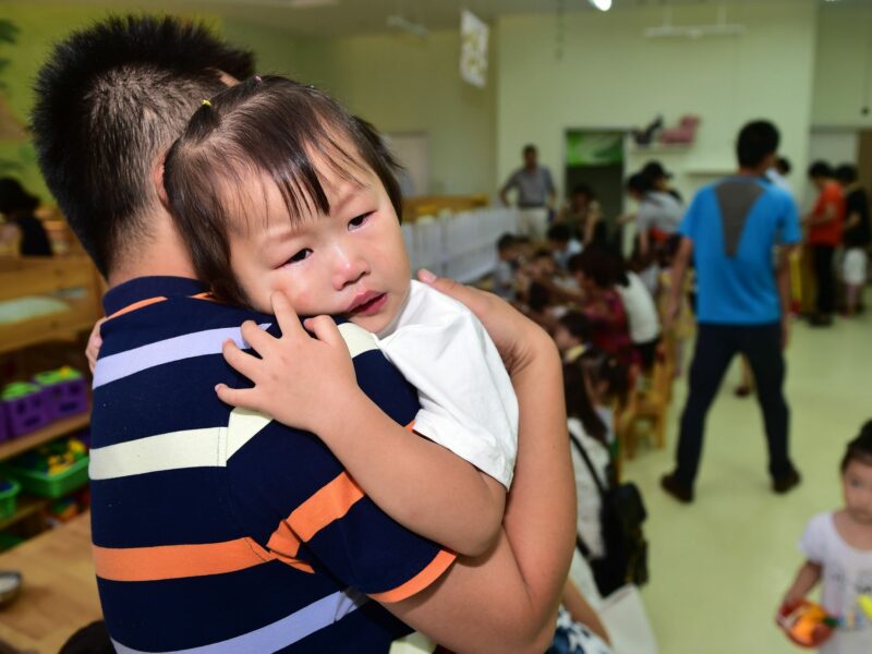 photo of father holding crying child