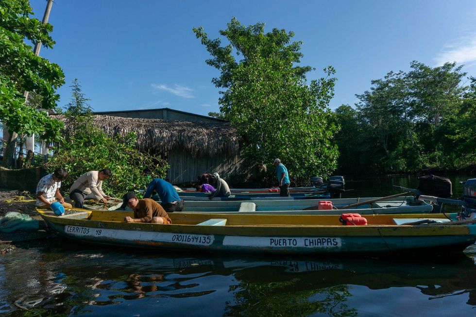 Photo of fishermen tying up their canoes.