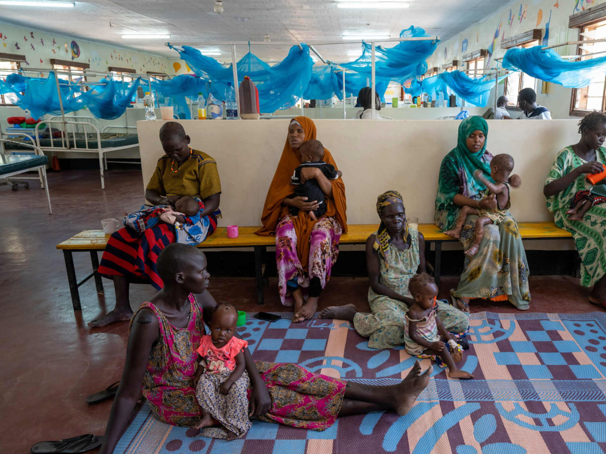 Photo of five mothers holding their malnourished children