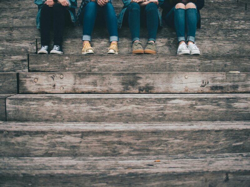 Photo of four teenaged people sitting on stairs